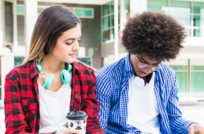 young-diverse-couple-sitting-outside-college-building